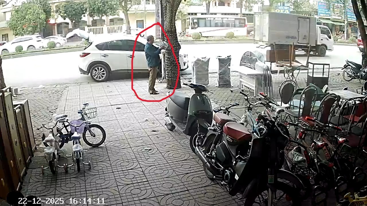 Người đàn ông lấy chiếc mũ bảo hiểm treo trên cây bỏ vào cốp ô tô