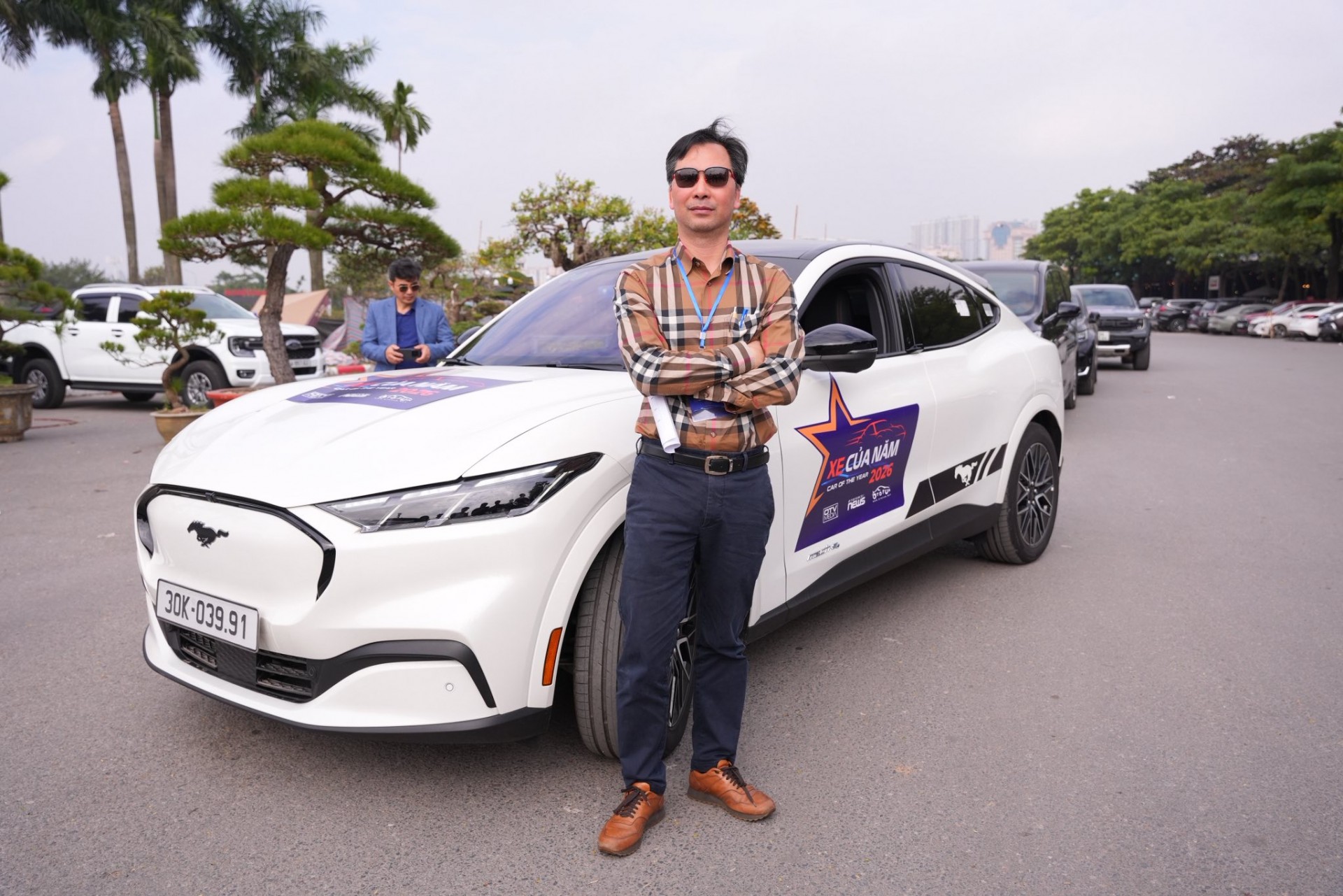 Ông Đàm Hoàng Phúc đứng cùng chiếc Ford Mustang Mach-E