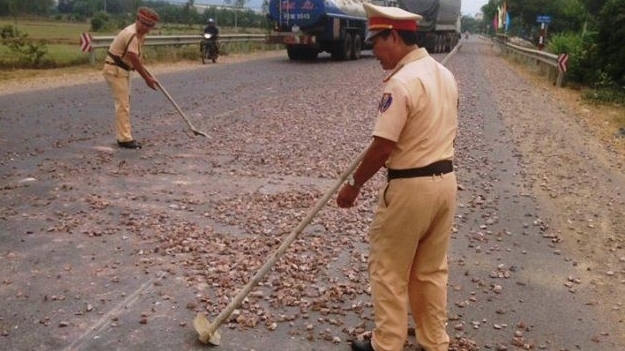 Cảnh sát giao thông dọn đá rơi vãi trên đường, đảm bảo an toàn giao thông
