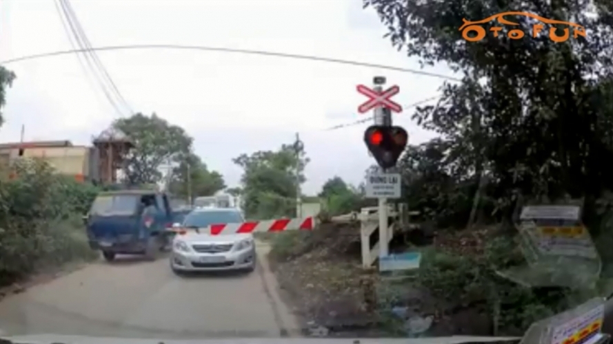 Ô tô, xe máy lũ lượt vượt barie băng qua đường ray trước mũi tàu hỏa